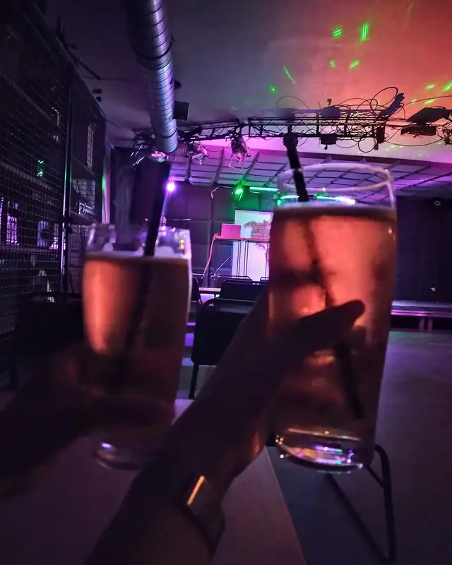 Drink z lodem w szklance w fioletowym świetle